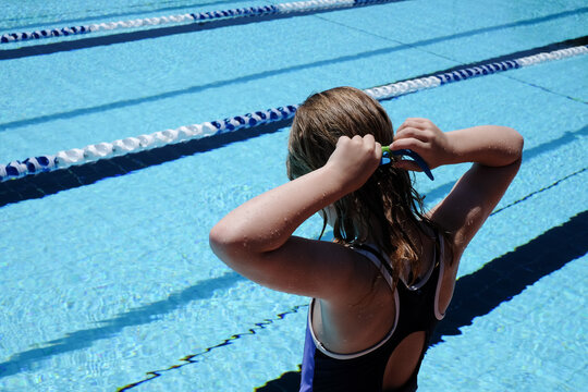 Young girl putting her googles on for swimming