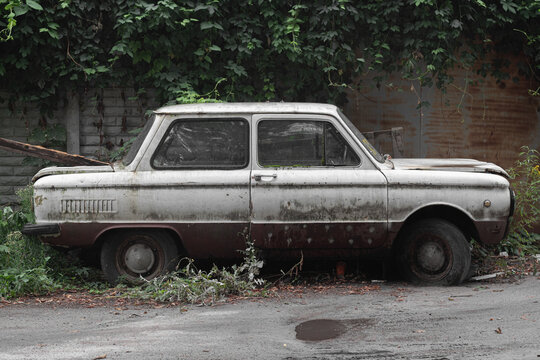 Old abandoned white Soviet car, brand "Zaporozhets". Kyiv, Ukraine - September 2021.