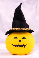 Funny pumpkin in a witch hat on a white background. Halloween decoration.