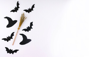 Halloween set of witch hat, broomstick and black bats on a white background. Copy space.