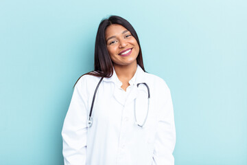 Young doctor Venezuelan woman isolated on blue background happy, smiling and cheerful.