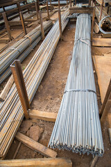 Bundles of metal corrugated reinforcement located on separate racks. Construction production technology backgrounds.