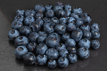 Blueberries fruit background. Water drops on ripe sweet blueberry. Collection of blue and black berries. Conceptual food image..