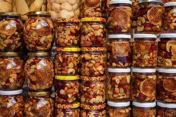 Nuts with honey in glass jars. Harvest of nuts. Delicacy and Healthy food. Homemade preservation in autumn.