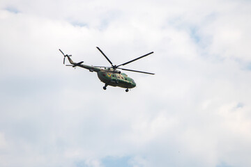 Fototapeta na wymiar Helicopter flying against the blue sky