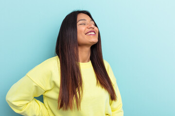 Young Venezuelan woman isolated on blue background relaxed and happy laughing, neck stretched showing teeth.