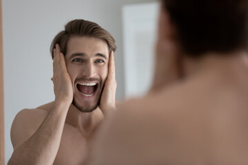 35s man shout looks in mirror touches his head open mouth feels stressed due facial rough, rash, dry, cracked skin symptom disorder. Wrinkles detected, need anti-ageing treatment, skin problem concept
