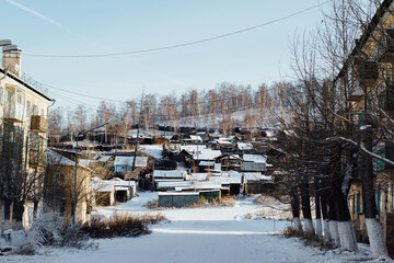 Street overlooking houses on a slope in Khakassia in the city of Sorsk in winter