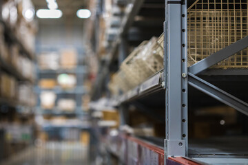 A modern warehouse with goods on folding metal shelves. Background blur, focusing with a small depth of field.