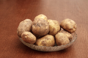 Fototapeta na wymiar plate with raw potatoes on the table