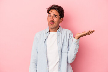 Young mixed race man isolated on white background doubting and shrugging shoulders in questioning gesture.