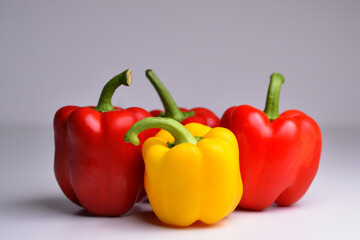 Four bell peppers, red, and grey on white background. Organic healthy food. Peppers. Paprika. Bell pepper isolated. Sweet pepper. With clipping path. Full depth of field.