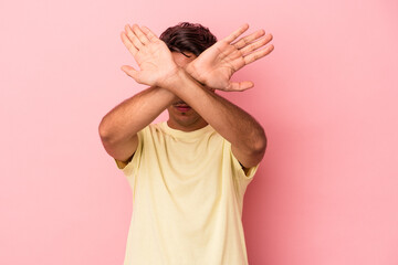 Young mixed race man isolated on white background keeping two arms crossed, denial concept.