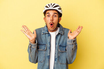 Young mixed race man wearing a helmet bike isolated on yellow background surprised and shocked.