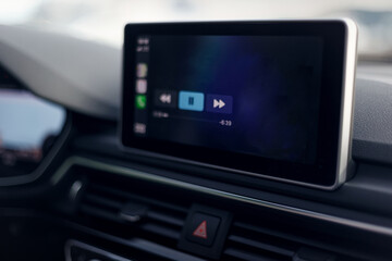Car multimedia system. Glowing beautiful dashboard of a modern expensive car. The interior of the car. The foreground is blurred. Modern car interior details. Selective focus