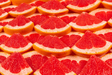 Grapefruit red juicy slices background. top view.