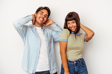 Fototapeta premium Young mixed race couple isolated on white background stretching arms, relaxed position.