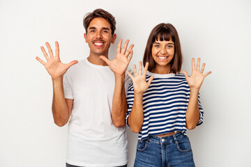 Young mixed race couple isolated on white background showing number ten with hands.