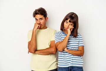 Naklejka premium Young mixed race couple isolated on white background tired of a repetitive task.