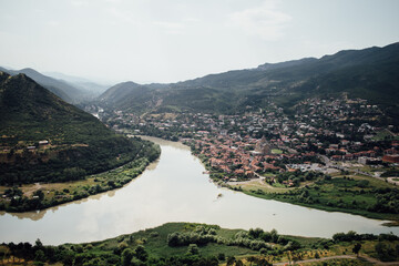 Beautiful natural landscape with a city and mountains and a flowing river in Georgia