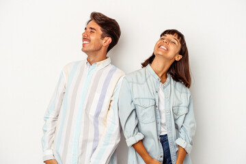 Young mixed race couple isolated on white background relaxed and happy laughing, neck stretched showing teeth.