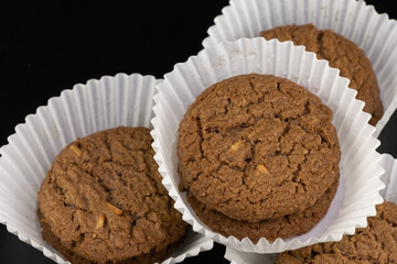 Delicious tasty snack of brown cookies with chocolate chip and peanut isolated on black background