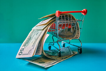 concept - curled dollar banknotes fall out of Shopping Cart Trolley against the green background
