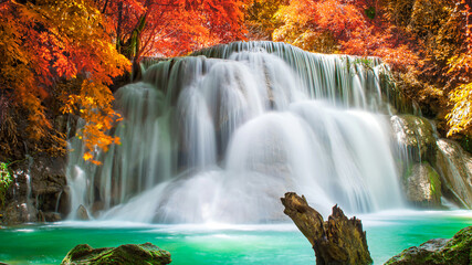 Amazing in nature, beautiful waterfall at colorful autumn forest in fall season. 	