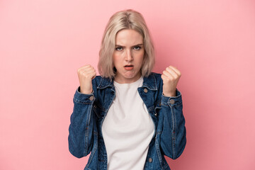 Young caucasian woman isolated on pink background upset screaming with tense hands.