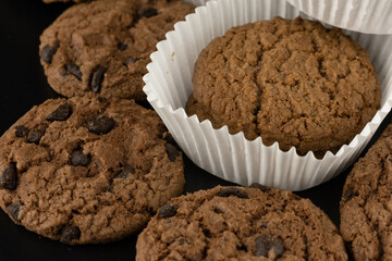 Delicious tasty snack of brown cookies with chocolate chip and peanut isolated on black background
