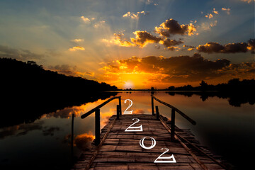 bridge in the lake on the background of the sunrise and the numbers 2022, new year 2022 concept
