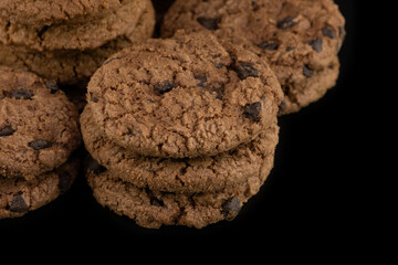 Delicious tasty snack of brown cookies with chocolate chip and peanut isolated on black background