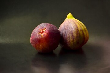 a couple of ripe fig fruits close-up on a black background