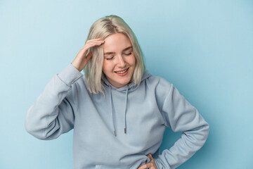 Young caucasian woman isolated on blue background joyful laughing a lot. Happiness concept.