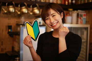 初心者マークを持つ女性店員