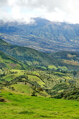 Fototapeta na wymiar Farms on rolling hills below the mountains, near Lago Mojanda, Imbabura Province, Ecuador