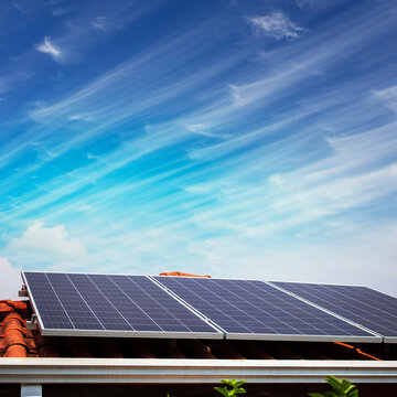 Solar panels on the red roof in a sunny and cloudy day. Photovoltaic instalation image.
