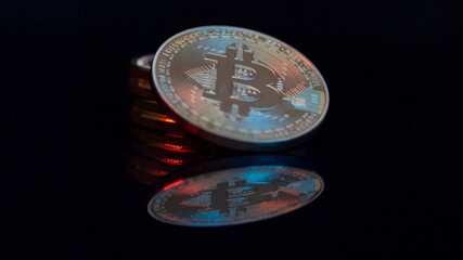 Bitcoin Münzen vor einem dunklen Hintergrund mit Spiegelungen