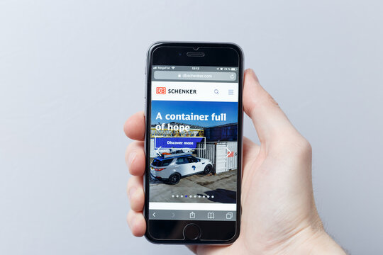 Moscow / Russia - 04.21.2019: A hand holding a smartphone which displays DB Schenker Logistics logo on the official website homepage. logo visible on smartphone screen. Illustrative editorial