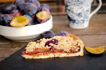 Piece of delicious crumble plum tart, homemade plum pie - crumble cake
