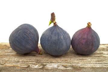 Whole figs on wooden table over a white background