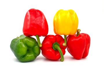 Red, green and yellow bell peppers on white