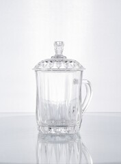 Jarra de cristal con forma para te chino en fondo blanco gris 