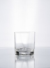 Vaso de cristal con forma para whisky en fondo blanco gris 