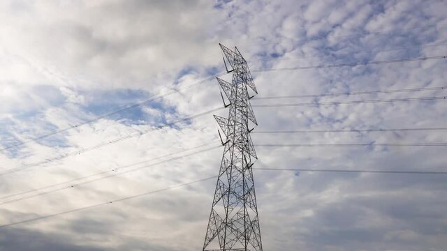 Time-lapse - clouds moving over the pilon or electricity tower