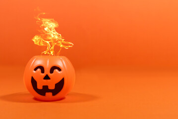 Calabaza sacando fuego en fondo naranja, con espacio para texto. Halloween.