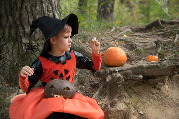 Beautiful girl witch conjures. The girl is dressed in a witch costume for the Halloween holiday....