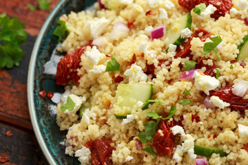 Couscous salad with sun dried tomatoes, cucumber, red onion and feta cheese. healthy food.