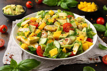 Tasty Chicken mango salad with avocado, cucumber, cherry tomatoes. Healthy food