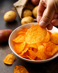 Paprika Potato Chips in white bowl on rustic background